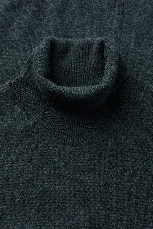 캐시미어 100% 풀 터틀넥 니트입니다. 부드러운 촉감과 두꺼운 두께감으로 겨울철 따뜻하게 착용하기 좋습니다. 차콜 그레이 색상에 베이직한 디자인으로, 출근룩이나 오피스룩 등 다양한 스타일에 활용할 수 있습니다. 2/26수 원사를 사용하여 고급스러운 퀄리티를 자랑하며, 탄탄한 넥 라인이 특징입니다. 겨울 시즌 이너 아이템으로 활용하기 좋은 레귤러 핏의 긴소매 니트입니다.
