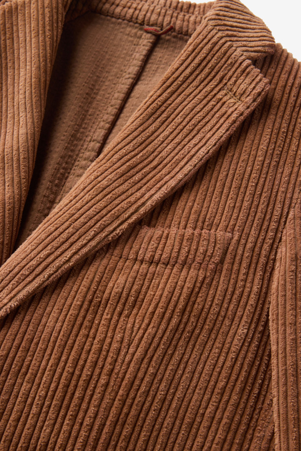 SANTANIELLO(산타니엘로) 볼드 코듀로이 재킷입니다. 짙은 브라운 컬러의 부드러운 코듀로이 소재로 제작되어 가을, 겨울 시즌 따뜻하고 포근하게 착용할 수 있습니다. 레귤러 핏에 싱글 버튼 여밈 방식, 긴 소매 기장으로 캐주얼하고 클래식한 분위기를 연출합니다. 출근룩과 모임룩 모두 활용 가능하며, 무지 디자인으로 미니멀한 스타일을 즐기는 분들께 추천합니다. 두꺼운 두께감으로 보온성을 높였습니다.
