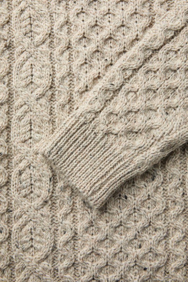 PEREGRINE(페레그린) 허드슨 아란 니트는 남성용 상의 니트/스웨터 제품입니다. 베이지 색상의 레귤러핏 라운드넥 긴소매 울 혼방 니트로, 가을/겨울 시즌에 착용하기 좋습니다. 클래식 스타일의 이 니트는 아란 니트 패턴과 입체적인 짜임, 도톰한 조직감으로 포근하고 따뜻한 착용감을 선사합니다. 출근룩과 모임룩 모두에 잘 어울리며, 미니멀, 캐주얼 스타일과도 매치하기 좋습니다.
