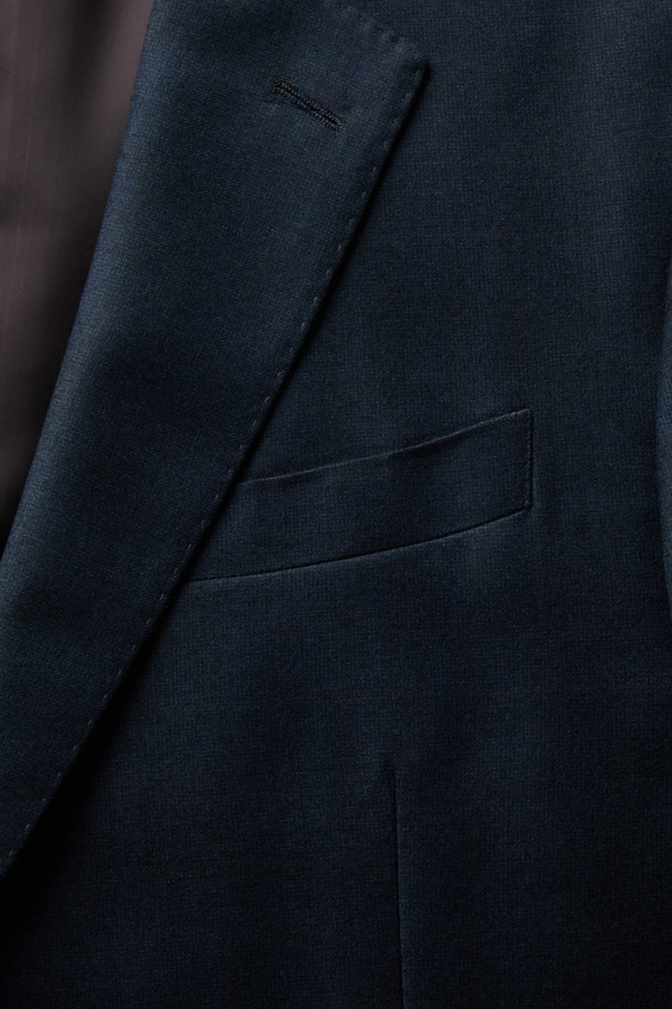 제냐 울캐시 쉐도우체크 수트 재킷 (Navy)는 포멀하고 클래식한 스타일을 추구하는 남성을 위한 겨울철 필수 아이템입니다. 부드러운 울과 캐시미어 혼방 소재로 제작되어 뛰어난 착용감과 보온성을 제공하며, 은은한 광택과 마이크로 조직감, 세미 밀드 가공으로 고급스러운 분위기를 더합니다. 네이비 컬러 바탕에 섬세한 쉐도우 체크 패턴이 적용되어 세련된 느낌을 선사하며, 레귤러핏 싱글버튼 디자인으로 오피스룩, 비즈니스 캐주얼, 출근룩 등 다양한 TPO에 활용 가능합니다. 긴 소매 기장과 두꺼운 두께감으로 겨울철에도 따뜻하고 스타일리시하게 연출할 수 있습니다.
