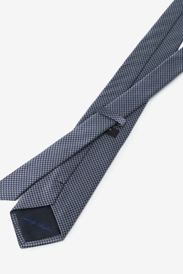 클래식한 디자인의 남성용 실크 하운드투스 올오버 넥타이입니다. 부드러운 촉감의 고급 실크 소재로 제작되어 포멀한 착장에 잘 어울립니다. 그레이 컬러의 하운드투스 패턴이 세련된 느낌을 주며, 루프 디테일이 돋보입니다. 오피스룩, 비즈니스 캐주얼, 모임룩 등 다양한 TPO에 활용 가능하며, 미니멀하고 클래식한 스타일을 연출하기 좋습니다.
