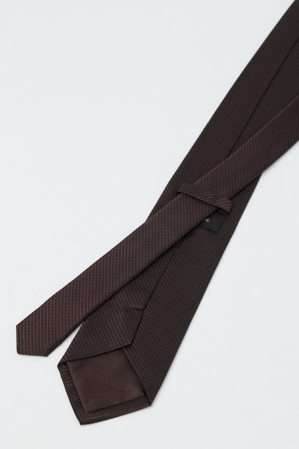 **실크 텍스쳐 솔리드 타이**는 남성용 포멀 넥타이입니다. 부드러운 촉감의 블랙 솔리드 컬러 실크 소재로 제작되어 클래식하고 시크한 스타일을 연출합니다. 오피스룩, 비즈니스 캐주얼, 모임룩 등 다양한 TPO에 활용 가능하며, 얇은 두께감으로 답답함 없이 착용할 수 있습니다. 넥타이 끝단에는 로고 자수가 디자인되어 섬세한 포인트를 더합니다.
