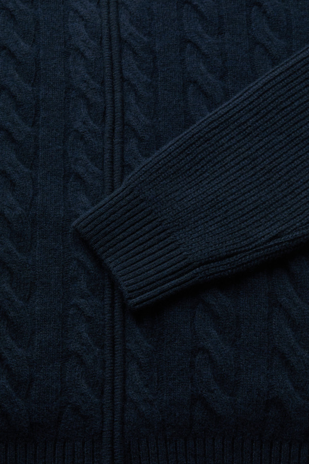 네이비 컬러의 울 캐시 케이블 후디 집업 니트입니다. 부드러운 촉감의 울과 캐시미어 혼방 소재로 제작되어 가을, 겨울 시즌에 따뜻하게 착용하기 좋습니다. 레귤러핏으로 편안하게 떨어지는 핏이며, 볼륨감 있는 케이블 조직과 하찌 조직, 후드 디자인이 특징입니다. 2-WAY 지퍼로 다양한 스타일 연출이 가능하며, 캐주얼, 클래식, 미니멀 스타일을 즐겨 입는 분들께 추천합니다. 집콕룩으로 편안하게, 또는 다양한 스타일링으로 활용해보세요.
