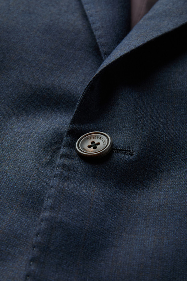 제냐 울캐시 쉐도우체크 수트 재킷 (Navy)는 포멀하고 클래식한 스타일을 추구하는 남성을 위한 겨울철 필수 아이템입니다. 부드러운 울과 캐시미어 혼방 소재로 제작되어 뛰어난 착용감과 보온성을 제공하며, 은은한 광택과 마이크로 조직감, 세미 밀드 가공으로 고급스러운 분위기를 더합니다. 네이비 컬러 바탕에 섬세한 쉐도우 체크 패턴이 적용되어 세련된 느낌을 선사하며, 레귤러핏 싱글버튼 디자인으로 오피스룩, 비즈니스 캐주얼, 출근룩 등 다양한 TPO에 활용 가능합니다. 긴 소매 기장과 두꺼운 두께감으로 겨울철에도 따뜻하고 스타일리시하게 연출할 수 있습니다.
