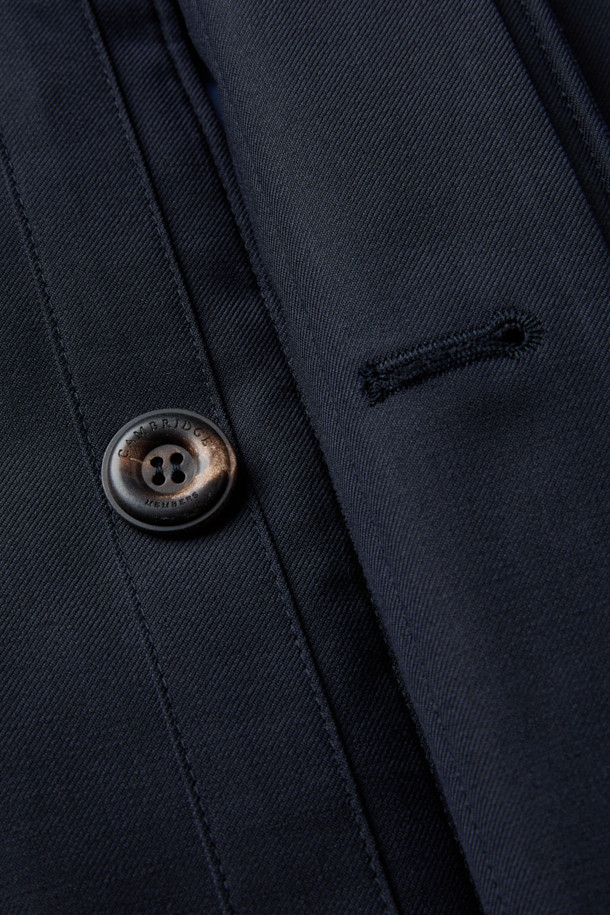 로로피아나 스톰 원단으로 제작된 남성용 구스다운 런던코트입니다. 네이비 컬러의 롱 기장 코트로, 클래식하고 포멀한 스타일을 연출합니다. 겨울철 보온을 위한 두꺼운 두께감과 방수, 방풍 기능을 갖춰 뛰어난 실용성을 자랑합니다. 레귤러핏으로 제작되었으며, 무지 디자인에 버튼 여밈 방식을 적용했습니다. 출근룩, 오피스룩, 모임룩 등 다양한 TPO에 활용 가능한, 미니멀하고 시크한 겨울철 필수 아이템입니다.
