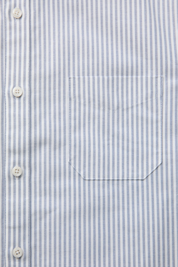 SOMELOS(소멜로스) 스트라이프 옥스포드 셔츠는 블루와 화이트 컬러의 조화가 돋보이는 셔츠입니다. 면 소재의 옥스포드 원단으로 제작되어 부드러운 촉감을 선사하며, 봄, 여름 시즌에 적합합니다. 캐주얼, 베이직, 미니멀 스타일을 소화하며, 출근룩 또는 비즈니스 캐주얼로 활용하기 좋습니다. 긴소매와 레귤러 기장으로, 다양한 하의와 편안하게 매치할 수 있습니다. 촘촘한 스트라이프 패턴이 세련된 느낌을 더합니다.
