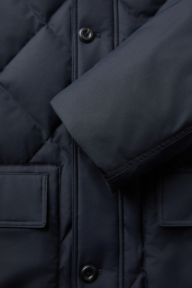 듀크 구스다운 파카는 겨울철 캐주얼 및 일상룩에 적합한 남성용 아우터입니다. 네이비 색상의 무지 디자인으로, 후드 탈착이 가능하며 경량 구스다운 충전재를 사용하여 보온성을 높였습니다. 지퍼와 버튼으로 여밀 수 있으며, 중기장 기장의 레귤러핏으로 제작되어 편안한 착용감을 제공합니다. 출근룩과 여행룩 모두 소화 가능한 미니멀하고 베이직한 스타일의 파카입니다. 
