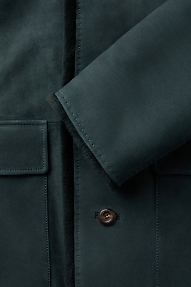 **베이비카프 스탠카라 풀퍼**는 여성용 아우터로, 가을과 겨울에 착용하기 좋은 두꺼운 소가죽 재킷입니다. 클래식하고 캐주얼한 스타일을 아우르며, 일상과 출근룩, 모임룩에 모두 잘 어울립니다. 그린 컬러의 무지 디자인에 하프 기장, 스탠카라, 긴 소매, 버튼 여밈 방식이 특징입니다. 안감은 퍼 소재로 제작되어 부드러운 촉감과 뛰어난 보온성을 제공합니다. 레귤러핏으로 제작되어 편안하게 착용 가능하며, 미니멀한 스타일을 선호하는 분들께 추천합니다.
