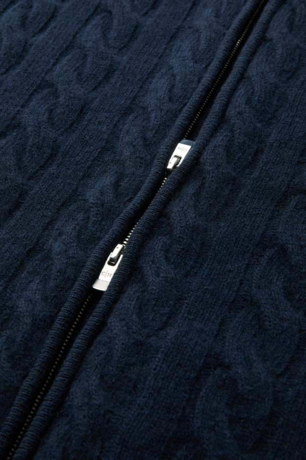 네이비 컬러의 울 캐시 케이블 후디 집업 니트입니다. 부드러운 촉감의 울과 캐시미어 혼방 소재로 제작되어 가을, 겨울 시즌에 따뜻하게 착용하기 좋습니다. 레귤러핏으로 편안하게 떨어지는 핏이며, 볼륨감 있는 케이블 조직과 하찌 조직, 후드 디자인이 특징입니다. 2-WAY 지퍼로 다양한 스타일 연출이 가능하며, 캐주얼, 클래식, 미니멀 스타일을 즐겨 입는 분들께 추천합니다. 집콕룩으로 편안하게, 또는 다양한 스타일링으로 활용해보세요.
