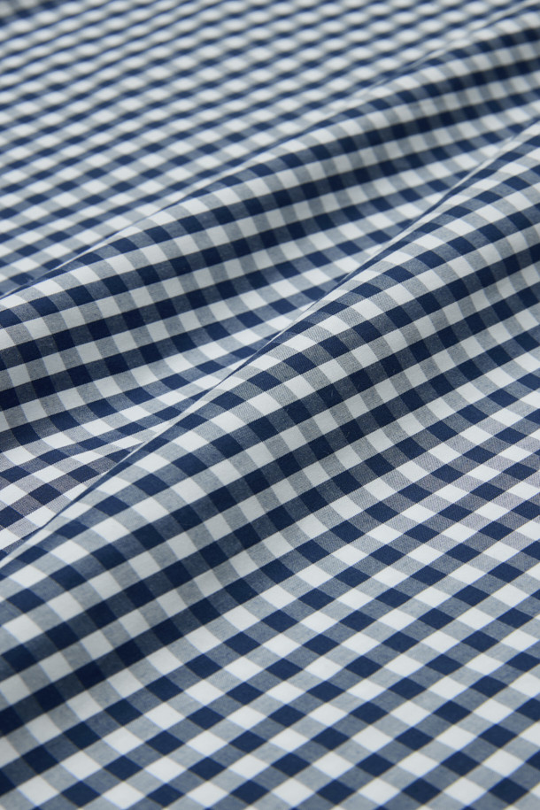 네이비와 화이트 컬러의 깅엄 체크 패턴이 돋보이는 남성용 드레스셔츠입니다. 봄, 여름, 가을 계절에 착용하기 좋으며, 레귤러핏으로 제작되어 편안한 착용감을 선사합니다. 와이드 칼라 디자인에 얇은 두께감으로 시원하게 입을 수 있으며, 롤업 가능한 긴 소매는 다양한 스타일 연출을 돕습니다. 센터 풀 버튼, 소맷단 2버튼, 칼라 심지 처리 디테일이 돋보이며, 오피스룩, 비즈니스 캐주얼, 모임룩 등 TPO에 맞춰 클래식하고 미니멀한 스타일을 연출하기 좋습니다. 면 소재로 제작되어 부드러운 촉감을 느낄 수 있습니다.
