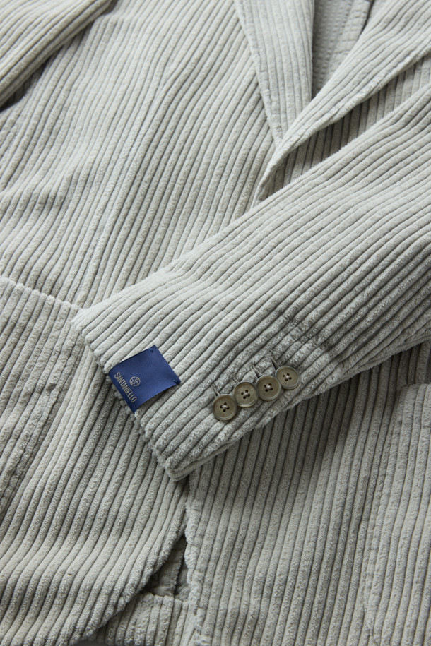 **SANTANIELLO(산타니엘로) 볼드 코듀로이 재킷**은 남성용 자켓으로, 캐주얼, 클래식, 미니멀 스타일을 모두 아우르는 매력적인 아이템입니다. 봄, 가을에 착용하기 적합하며, 출근룩으로도 활용할 수 있습니다. 그레이 컬러의 레귤러핏 자켓으로, 볼드한 코듀로이 원단과 싱글 버튼 디테일이 특징입니다. 두께감 있는 코듀로이 소재는 뻣뻣한 촉감을 선사하며, 긴 소매 기장으로 제작되었습니다. 
