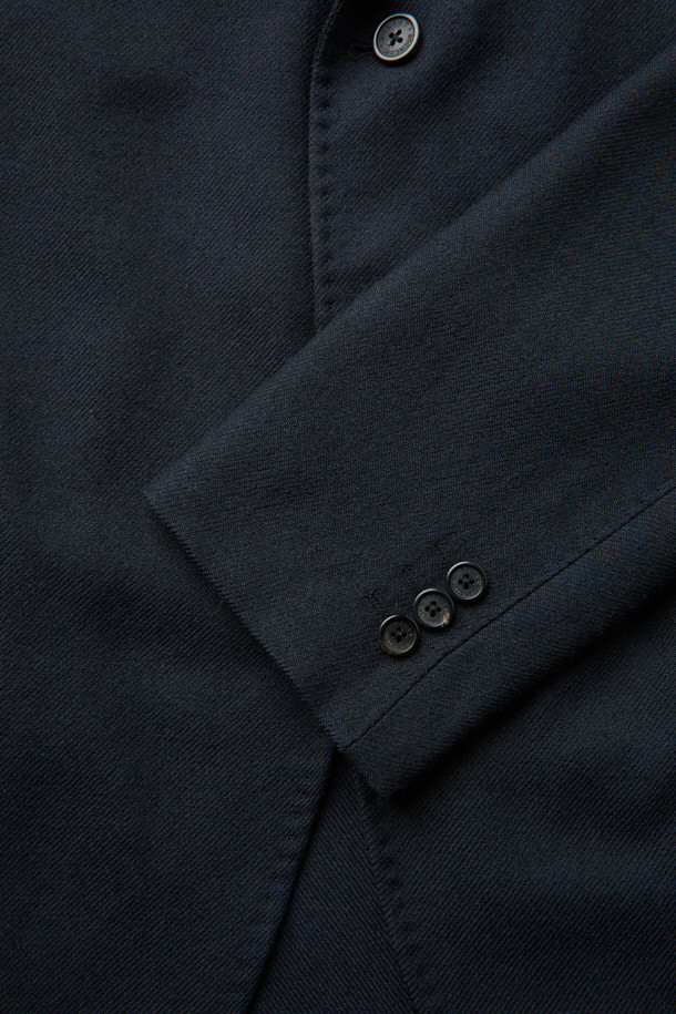 MOVERE X ROLIAT 테일러드 재킷은 가을과 겨울에 어울리는 블랙 컬러의 울 소재 싱글 버튼 재킷입니다. 레귤러 핏으로 제작되었으며, 미니멀하고 클래식한 스타일을 연출합니다. 다트 디테일과 밀드 가공, 트윌 조직으로 마감하여 고급스러운 촉감과 두꺼운 두께감을 느낄 수 있습니다. 오피스룩, 비즈니스 캐주얼, 모임룩 등 다양한 TPO에 활용하기 좋습니다. 시크하고 세련된 스타일을 완성해 보세요.
