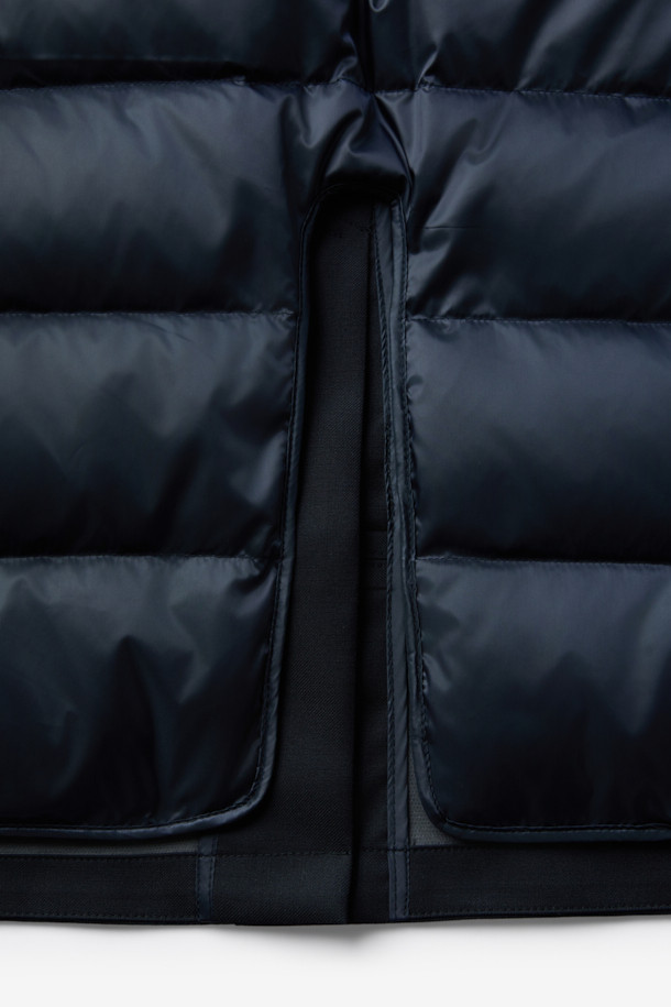 로로피아나 스톰 원단으로 제작된 남성용 구스다운 런던코트입니다. 네이비 컬러의 롱 기장 코트로, 클래식하고 포멀한 스타일을 연출합니다. 겨울철 보온을 위한 두꺼운 두께감과 방수, 방풍 기능을 갖춰 뛰어난 실용성을 자랑합니다. 레귤러핏으로 제작되었으며, 무지 디자인에 버튼 여밈 방식을 적용했습니다. 출근룩, 오피스룩, 모임룩 등 다양한 TPO에 활용 가능한, 미니멀하고 시크한 겨울철 필수 아이템입니다.
