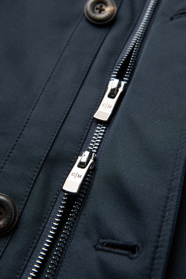 네이비 컬러의 스탠드 니트카라 구스다운 트렌치 코트입니다. 캐주얼, 클래식, 미니멀한 스타일을 모두 아우르는 디자인으로, 일상과 출근룩에 모두 활용 가능합니다. 두꺼운 두께감으로 겨울철 보온성을 높였으며, 유로피안 구스다운 충전재와 메리노 무스탕 배색으로 고급스러움을 더했습니다. 스탠드 카라와 니트 카라 디테일이 돋보이며, 레귤러핏으로 편안하게 착용할 수 있습니다. 경량 기능으로 활동성 또한 놓치지 않았습니다.
