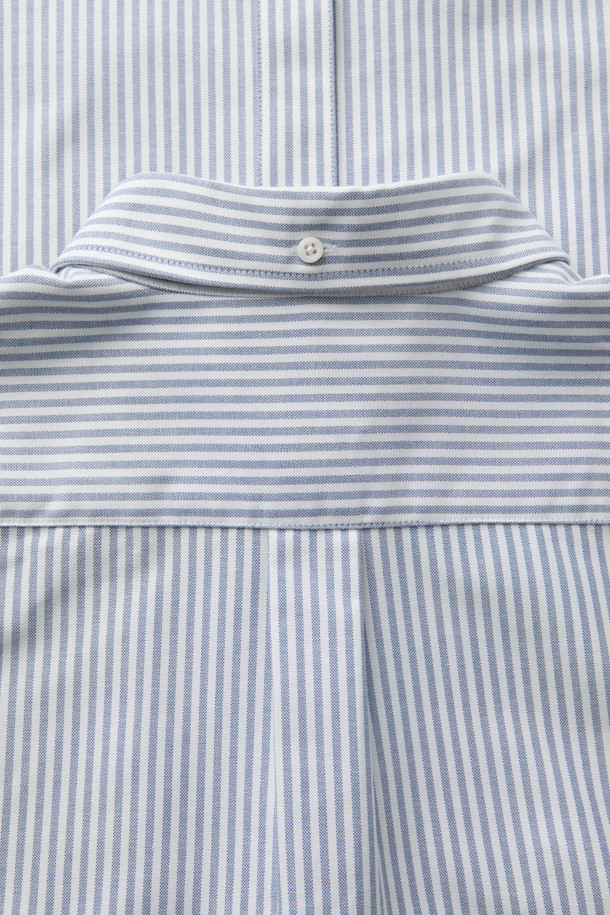 SOMELOS(소멜로스) 스트라이프 옥스포드 셔츠는 블루와 화이트 컬러의 조화가 돋보이는 셔츠입니다. 면 소재의 옥스포드 원단으로 제작되어 부드러운 촉감을 선사하며, 봄, 여름 시즌에 적합합니다. 캐주얼, 베이직, 미니멀 스타일을 소화하며, 출근룩 또는 비즈니스 캐주얼로 활용하기 좋습니다. 긴소매와 레귤러 기장으로, 다양한 하의와 편안하게 매치할 수 있습니다. 촘촘한 스트라이프 패턴이 세련된 느낌을 더합니다.
