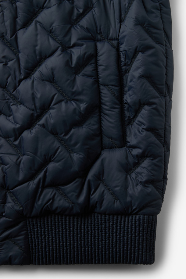 COSTUMEIN (코스튬인) 톰 퀼티드 점퍼는 남녀 모두 착용 가능한 캐주얼하고 미니멀한 스타일의 점퍼입니다. 봄, 가을에 어울리는 얇은 두께감과 가벼운 착용감으로 일상, 출근룩, 산책룩 등 다양한 TPO에 활용하기 좋습니다. 네이비 컬러의 퀼팅 패턴이 특징이며, 레귤러 핏과 긴 소매, 립 디테일이 편안하고 세련된 분위기를 연출합니다. 집업 스타일로 간편하게 착용 가능하며, 경량 소재로 제작되어 활동성을 높였습니다.
