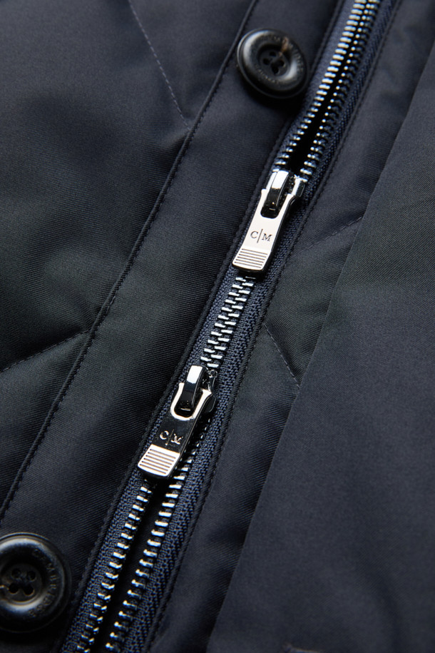 듀크 구스다운 파카는 겨울철 캐주얼 및 일상룩에 적합한 남성용 아우터입니다. 네이비 색상의 무지 디자인으로, 후드 탈착이 가능하며 경량 구스다운 충전재를 사용하여 보온성을 높였습니다. 지퍼와 버튼으로 여밀 수 있으며, 중기장 기장의 레귤러핏으로 제작되어 편안한 착용감을 제공합니다. 출근룩과 여행룩 모두 소화 가능한 미니멀하고 베이직한 스타일의 파카입니다. 
