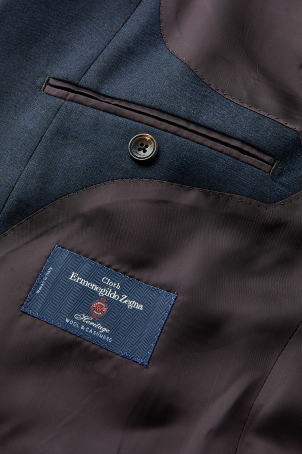 제냐 울캐시 쉐도우체크 수트 재킷 (Navy)는 포멀하고 클래식한 스타일을 추구하는 남성을 위한 겨울철 필수 아이템입니다. 부드러운 울과 캐시미어 혼방 소재로 제작되어 뛰어난 착용감과 보온성을 제공하며, 은은한 광택과 마이크로 조직감, 세미 밀드 가공으로 고급스러운 분위기를 더합니다. 네이비 컬러 바탕에 섬세한 쉐도우 체크 패턴이 적용되어 세련된 느낌을 선사하며, 레귤러핏 싱글버튼 디자인으로 오피스룩, 비즈니스 캐주얼, 출근룩 등 다양한 TPO에 활용 가능합니다. 긴 소매 기장과 두꺼운 두께감으로 겨울철에도 따뜻하고 스타일리시하게 연출할 수 있습니다.
