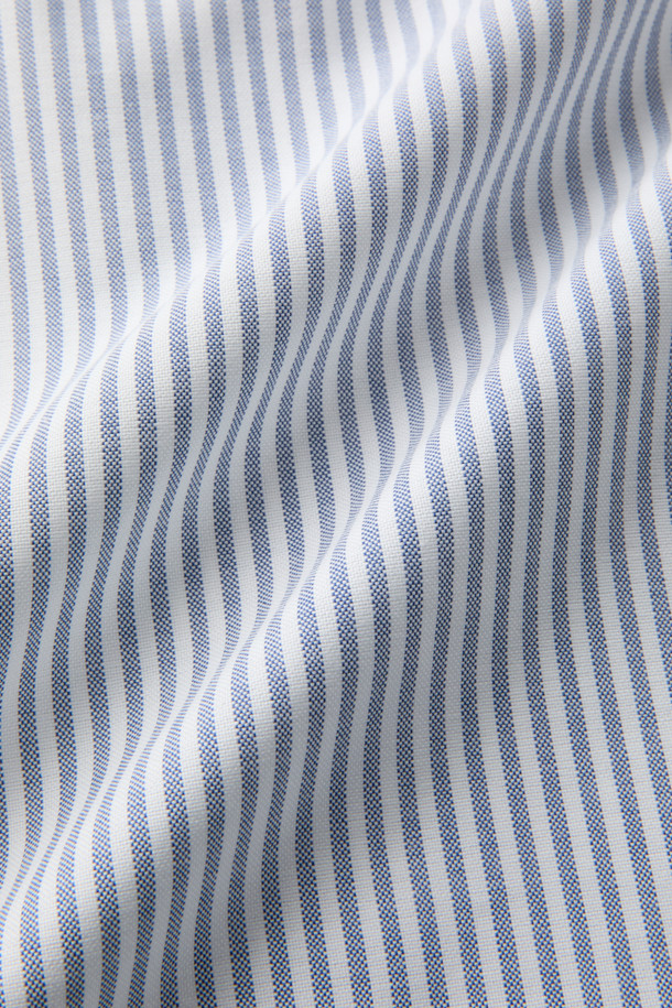 SOMELOS(소멜로스) 스트라이프 옥스포드 셔츠는 블루와 화이트 컬러의 조화가 돋보이는 셔츠입니다. 면 소재의 옥스포드 원단으로 제작되어 부드러운 촉감을 선사하며, 봄, 여름 시즌에 적합합니다. 캐주얼, 베이직, 미니멀 스타일을 소화하며, 출근룩 또는 비즈니스 캐주얼로 활용하기 좋습니다. 긴소매와 레귤러 기장으로, 다양한 하의와 편안하게 매치할 수 있습니다. 촘촘한 스트라이프 패턴이 세련된 느낌을 더합니다.
