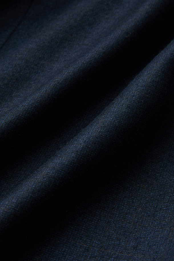 제냐 울캐시 쉐도우체크 수트 재킷 (Navy)는 포멀하고 클래식한 스타일을 추구하는 남성을 위한 겨울철 필수 아이템입니다. 부드러운 울과 캐시미어 혼방 소재로 제작되어 뛰어난 착용감과 보온성을 제공하며, 은은한 광택과 마이크로 조직감, 세미 밀드 가공으로 고급스러운 분위기를 더합니다. 네이비 컬러 바탕에 섬세한 쉐도우 체크 패턴이 적용되어 세련된 느낌을 선사하며, 레귤러핏 싱글버튼 디자인으로 오피스룩, 비즈니스 캐주얼, 출근룩 등 다양한 TPO에 활용 가능합니다. 긴 소매 기장과 두꺼운 두께감으로 겨울철에도 따뜻하고 스타일리시하게 연출할 수 있습니다.
