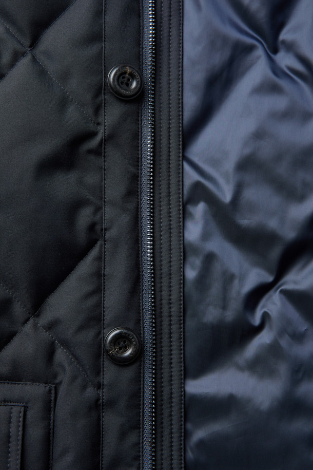 듀크 구스다운 파카는 겨울철 캐주얼 및 일상룩에 적합한 남성용 아우터입니다. 네이비 색상의 무지 디자인으로, 후드 탈착이 가능하며 경량 구스다운 충전재를 사용하여 보온성을 높였습니다. 지퍼와 버튼으로 여밀 수 있으며, 중기장 기장의 레귤러핏으로 제작되어 편안한 착용감을 제공합니다. 출근룩과 여행룩 모두 소화 가능한 미니멀하고 베이직한 스타일의 파카입니다. 
