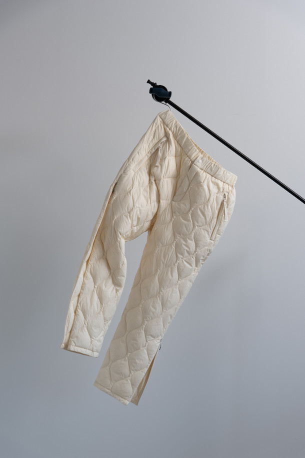 [타이온 X W.M] 라이트 다운 팬츠 - 오프 화이트는 일상, 아웃도어 활동에 적합한 유니섹스 다운 팬츠입니다. 800 필파워의 다운 충전재와 방수 기능으로 뛰어난 보온성과 경량성을 자랑하며, 부드러운 촉감과 레귤러 핏으로 편안한 착용감을 제공합니다. YKK 지퍼 및 스냅 버튼, 지퍼 포켓, 사이드 슬릿 지퍼 디테일로 실용성을 더했으며, 겨울철 여행룩, 캠핑룩, 등산룩에 활용하기 좋습니다. 미니멀하고 스포티한 스타일 연출에 용이하며, 손세탁이 가능합니다.
