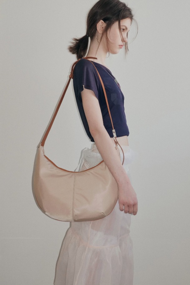 Faugeres Cross 41 나일론 크로스백은 여성용 미디엄 사이즈 가방입니다. 부드러운 나일론 소재로 제작되었으며, 무지 디자인에 반원 형태의 세련된 실루엣을 자랑합니다. 숄더 스트랩과 지퍼형 잠금 방식으로 편리함을 더했으며, 데이트룩과 출근룩 등 다양한 일상 스타일에 활용하기 좋습니다. 미니멀, 캐주얼, 클래식 스타일을 즐겨 입는 분들께 추천하는 아이템입니다.
