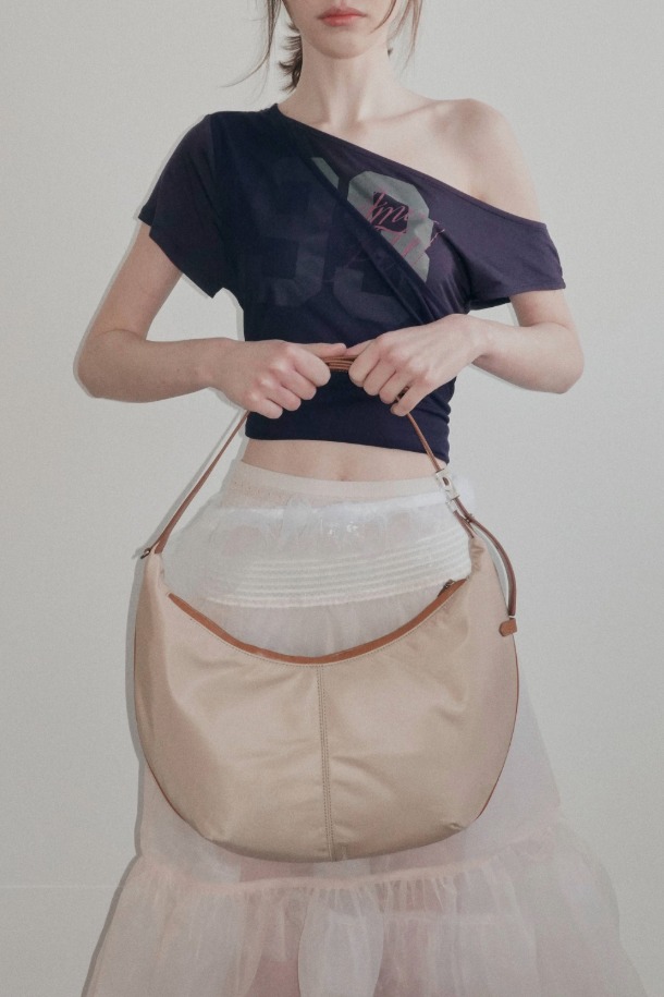 Faugeres Cross 41 나일론 크로스백은 여성용 미디엄 사이즈 가방입니다. 부드러운 나일론 소재로 제작되었으며, 무지 디자인에 반원 형태의 세련된 실루엣을 자랑합니다. 숄더 스트랩과 지퍼형 잠금 방식으로 편리함을 더했으며, 데이트룩과 출근룩 등 다양한 일상 스타일에 활용하기 좋습니다. 미니멀, 캐주얼, 클래식 스타일을 즐겨 입는 분들께 추천하는 아이템입니다.
