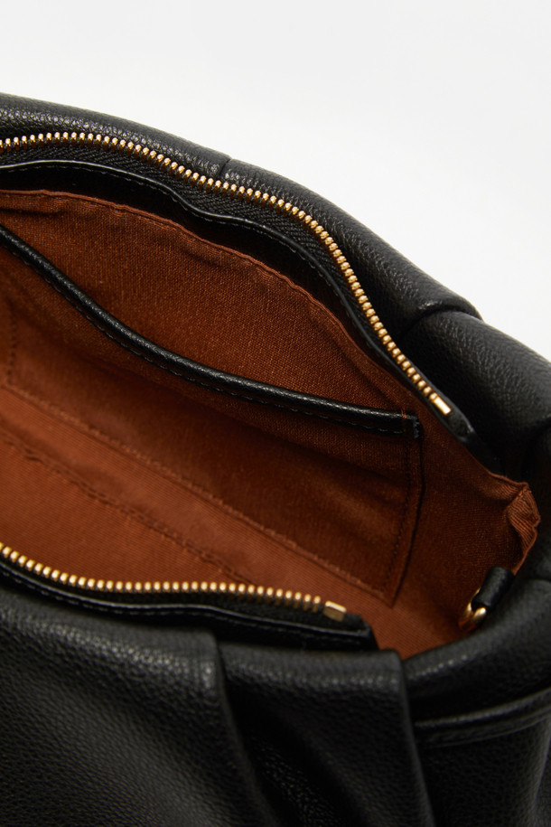 비아 크로스 25는 페미닌한 플리츠 바디와 스크류 디테일이 돋보이는 여성용 크로스백입니다. 부드러운 소가죽 소재와 미디엄 사이즈로 제작되어 데이트룩과 모임룩에 적합하며, 클래식, 미니멀, 걸리시 스타일을 모두 아우릅니다. 탈부착 가능한 스트랩으로 클러치백으로도 활용 가능하며, 내부에는 2개의 오픈 포켓이 있어 실용적입니다. 자연스러운 볼륨감을 살린 원통형 디자인과 골드 컬러 마감 브라스 하드웨어, 지퍼형 잠금 방식으로 고급스러움을 더했습니다.
