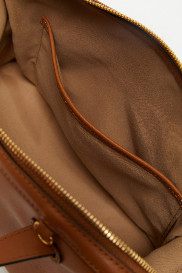 루보 토트 26은 자하 하디드의 건축물에서 영감을 받아 탄생한 여성 토트백입니다. 부드러운 네이키드 소가죽과 소가죽 소재로 제작되었으며, 브라운 컬러와 미니멀하고 클래식한 디자인이 특징입니다. 탈부착 및 길이 조절이 가능한 스트랩, 사각 형태, 골드 하드웨어 장식이 고급스러운 분위기를 더하며, 토트, 숄더, 크로스백으로 3way 연출이 가능합니다. 내부 지퍼 포켓 1개와 내부 포켓 1개가 있어 수납력을 높였으며, 오피스룩과 모임룩, 일상에서 시크하게 연출하기 좋습니다.
