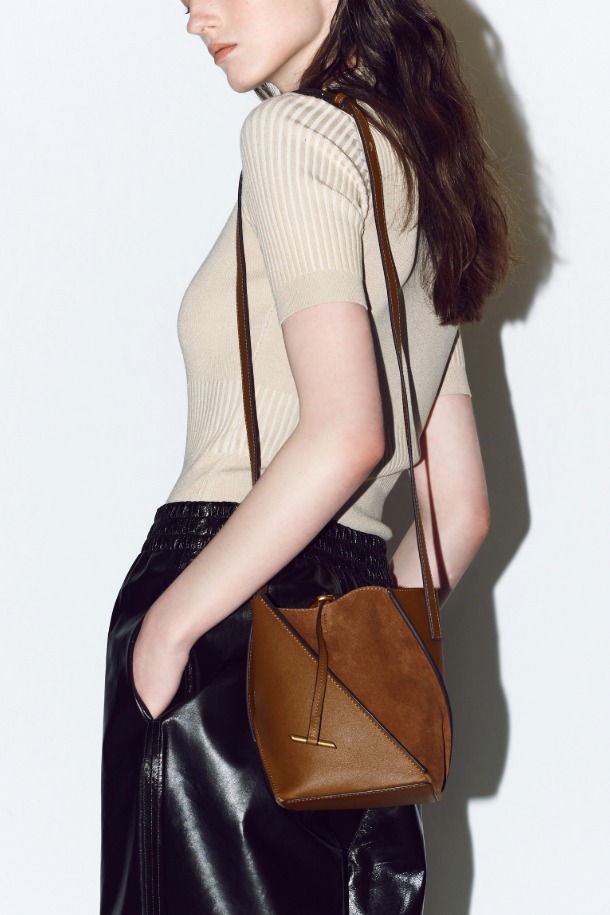 테넷 숄더 14 (Tenet Shoulder 14)는 여성스러운 스타일을 완성하는 미디엄 사이즈 숄더백입니다. 블랙과 브라운 두 가지 색상으로 출시되었으며, 소가죽과 스웨이드 소재의 조화가 고급스러운 분위기를 연출합니다. 링 장식과 사선 절개 디자인, 실버 하드웨어는 미니멀하면서도 시크한 매력을 더합니다. 탈부착 가능한 스트랩과 분리형 파우치, 3 way 연출, 스트랩 길이 조절 기능으로 실용성을 높였으며, 오피스룩과 모임룩에 활용하기 좋습니다.
