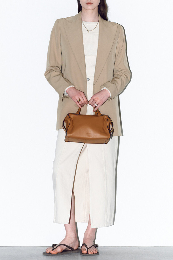 루보 토트 26은 자하 하디드의 건축물에서 영감을 받아 탄생한 여성 토트백입니다. 부드러운 네이키드 소가죽과 소가죽 소재로 제작되었으며, 브라운 컬러와 미니멀하고 클래식한 디자인이 특징입니다. 탈부착 및 길이 조절이 가능한 스트랩, 사각 형태, 골드 하드웨어 장식이 고급스러운 분위기를 더하며, 토트, 숄더, 크로스백으로 3way 연출이 가능합니다. 내부 지퍼 포켓 1개와 내부 포켓 1개가 있어 수납력을 높였으며, 오피스룩과 모임룩, 일상에서 시크하게 연출하기 좋습니다.
