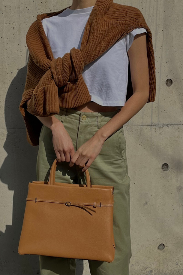 세련된 Adele 토트 36은 브라운과 카멜 두 가지 색상으로 출시된 여성용 토트백입니다. 가죽 소재로 제작되어 고급스러운 느낌을 주며, 미디엄 사이즈로 실용성을 더했습니다. 사각형 디자인에 지퍼형 잠금 방식으로 소지품을 안전하게 보관할 수 있습니다. 숄더 스트랩이 있어 숄더백으로도 활용 가능하며, 오피스룩, 비즈니스 캐주얼, 모임룩 등 다양한 TPO에 잘 어울립니다. 클래식, 미니멀, 시크 스타일을 즐겨 입는 여성에게 추천합니다.
