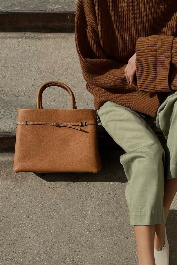 세련된 Adele 토트 36은 브라운과 카멜 두 가지 색상으로 출시된 여성용 토트백입니다. 가죽 소재로 제작되어 고급스러운 느낌을 주며, 미디엄 사이즈로 실용성을 더했습니다. 사각형 디자인에 지퍼형 잠금 방식으로 소지품을 안전하게 보관할 수 있습니다. 숄더 스트랩이 있어 숄더백으로도 활용 가능하며, 오피스룩, 비즈니스 캐주얼, 모임룩 등 다양한 TPO에 잘 어울립니다. 클래식, 미니멀, 시크 스타일을 즐겨 입는 여성에게 추천합니다.
