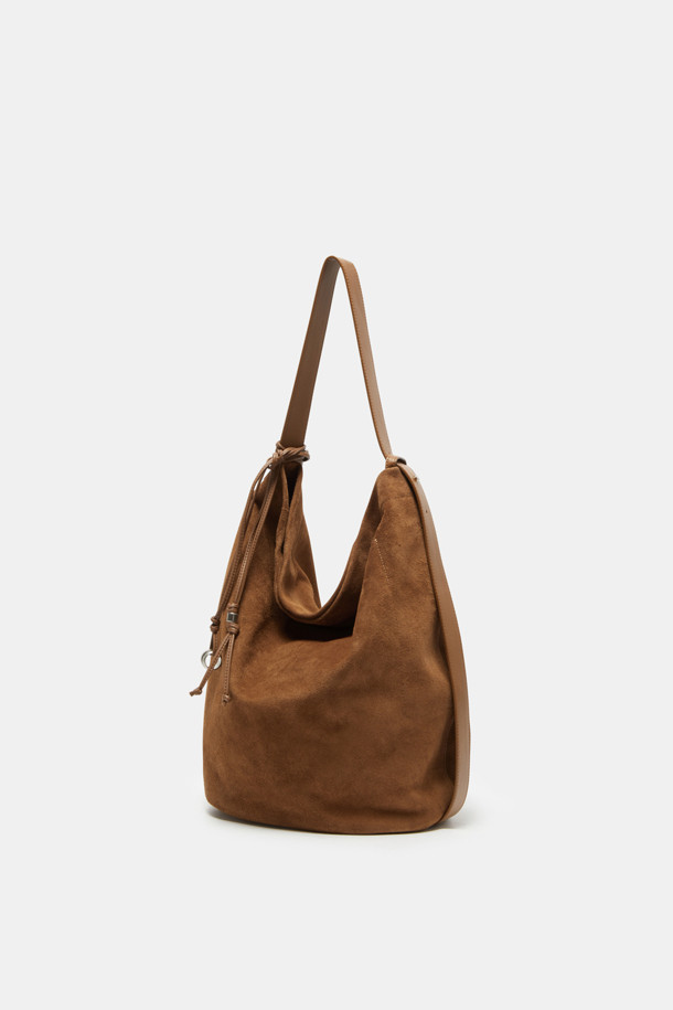 "Haru Shoulder 24 Suede(하루 숄더 24 스웨이드)"는 스웨이드와 가죽 소재의 조화가 돋보이는 미디엄 사이즈 숄더백입니다. 블랙과 브라운 두 가지 색상으로 출시되었으며, 은색 하드웨어 참 장식이 시크함을 더합니다. 탈부착 및 길이 조절 가능한 스트랩으로 2way 착용이 가능하며, 반원 형태의 디자인과 자연스러운 드레이핑 실루엣이 특징입니다. 

13인치 아이패드 수납이 가능하며, 내부에 포켓이 있어 실용성을 높였습니다. 깔끔한 외관과 마그네틱형 잠금 방식으로 데이트룩, 쇼핑룩 등 일상 용도로 폭넓게 활용할 수 있으며, 클래식, 미니멀, 시크 스타일을 연출하기에 좋습니다. 아이폰/아이패드/맥북 프로 수납이 가능하고, 사용할수록 자연스러운 에이징 효과를 느낄 수 있습니다.
