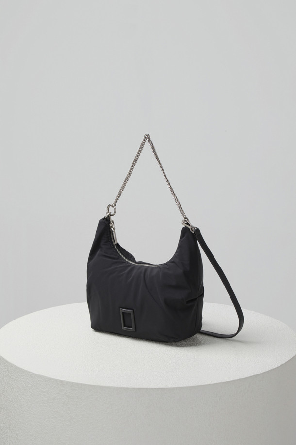 플러피 팝(Fluffy pop) 크로스 20은 여성용 크로스백으로, 미디엄 사이즈의 블랙 나일론 소재 무지 가방입니다. 반원 모양에 체인 장식이 더해져 미니멀, 클래식, 시크한 스타일을 연출합니다. 생활 방수 기능과 탈부착 가능한 스트랩으로 실용성을 높였으며, 자연스러운 주름 라인이 특징입니다. 내부에는 지퍼 포켓 1개와 일반 포켓 1개가 있어 수납이 용이하며, 브라스 소재 하드웨어가 고급스러움을 더합니다. 출근룩, 모임룩, 데이트룩 등 다양한 TPO에 활용 가능합니다.
