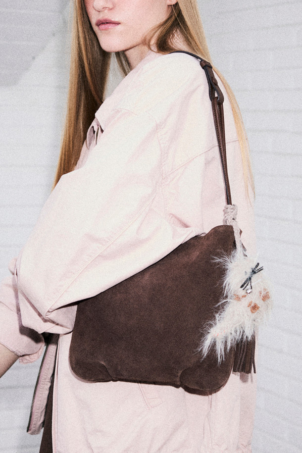 세련된 디자인의 미누 참(Minou Charm) 스웨이드 숄더백입니다. 부드러운 브라운 컬러와 반원 모양이 특징이며, 캐주얼한 스타일에 잘 어울립니다. 가을, 겨울 시즌에 따뜻함을 더해주는 스웨이드 소재로 제작되었으며, 앙증맞은 퍼와 태슬 장식이 포인트를 더합니다. 지퍼형 잠금 방식으로 소지품을 안전하게 보관할 수 있으며, 크로스백으로도 활용 가능합니다. 일상생활에서 스타일리시하게 연출하기 좋은 스몰 사이즈 가방입니다.
