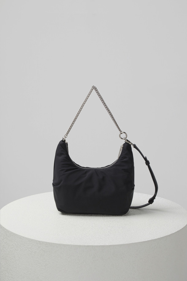 플러피 팝(Fluffy pop) 크로스 20은 여성용 크로스백으로, 미디엄 사이즈의 블랙 나일론 소재 무지 가방입니다. 반원 모양에 체인 장식이 더해져 미니멀, 클래식, 시크한 스타일을 연출합니다. 생활 방수 기능과 탈부착 가능한 스트랩으로 실용성을 높였으며, 자연스러운 주름 라인이 특징입니다. 내부에는 지퍼 포켓 1개와 일반 포켓 1개가 있어 수납이 용이하며, 브라스 소재 하드웨어가 고급스러움을 더합니다. 출근룩, 모임룩, 데이트룩 등 다양한 TPO에 활용 가능합니다.
