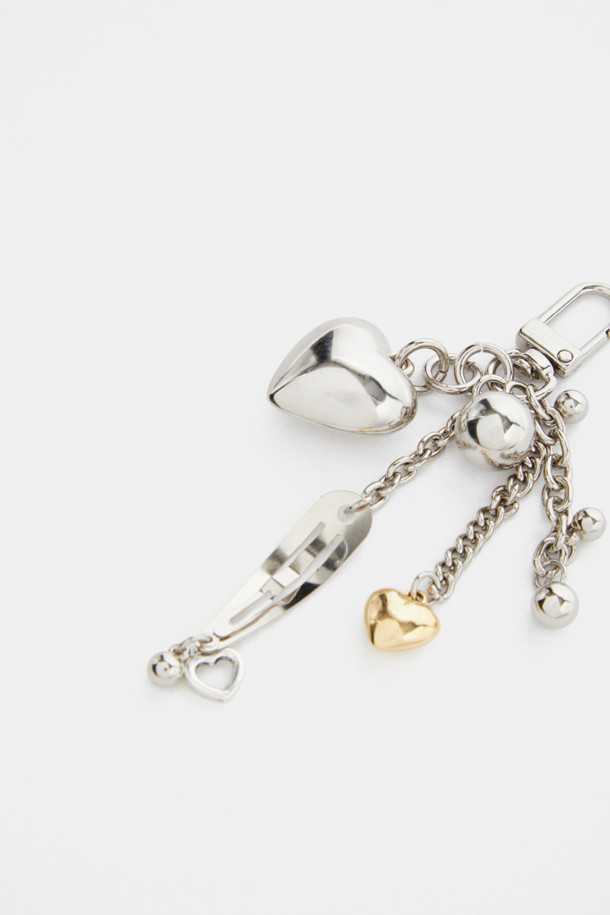 러브 클립 참은 엘레강스 무드를 연출하는 실버도금 메탈 소재의 액세서리입니다. 하트 펜던트, 볼 참, 체인, 레이저 각인 로고가 디자인되어 있으며, 스파클링한 실버 체인과 고급스러운 도금 마감이 특징입니다. 가방, 지퍼, 벨트 고리 등에 탈부착하여 개성 있는 스타일을 연출할 수 있습니다. 데이트룩, 모임룩, 쇼핑룩 등 다양한 TPO에 클래식, 로맨틱, 미니멀 스타일을 더해 보세요. 유니크하고 사랑스러운 무드를 선사합니다.
