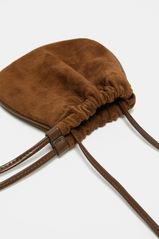 Bilo Cross Charm (비로 크로스 참)은 스웨이드와 합성가죽 소재의 미니 사이즈 복주머니 가방입니다. 브라운 컬러로 클래식, 미니멀, 캐주얼 스타일에 잘 어울리며, 데이트룩, 쇼핑룩에 포인트를 더할 수 있습니다. 조임용 끈으로 잠그는 방식으로, 내부 수납공간이 있어 에어팟, 립스틱 등 소지품을 안전하게 보관할 수 있습니다. 크로스백 또는 참 백으로 활용 가능하며, 길이를 조절하여 다양한 스타일로 연출할 수 있습니다. 다른 가방에 참으로 활용하여 나만의 개성을 표현해보세요.
