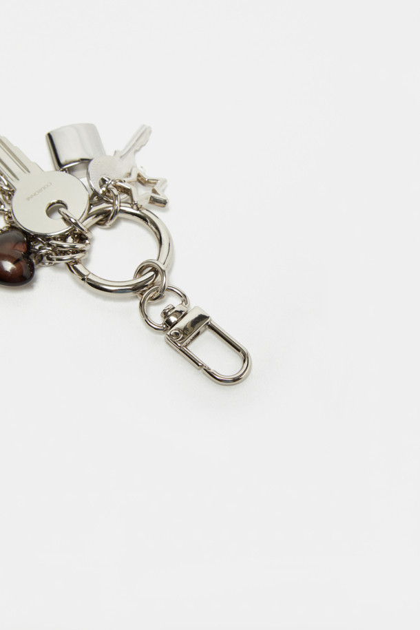 샤이닝 참은 은은하게 빛나는 실버 컬러의 메탈 소재 참장식입니다. 데일리룩, 쇼핑룩, 모임룩 등 다양한 TPO에 활용 가능하며, 미니멀, 캐주얼, 로맨틱 스타일을 연출하기 좋습니다. 하트, 별 모양의 펜던트와 체인, 참 장식이 혼합된 디자인으로 움직임에 따라 반짝이는 효과를 선사합니다. 탈부착이 가능하며, 니켈 도금 마감과 레이저 각인 로고로 고급스러움을 더했습니다.
