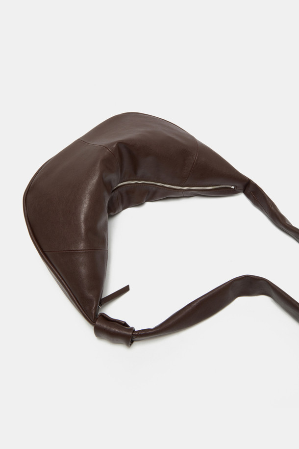 Faugeres 보우 크로스 47은 여성스러운 스타일을 강조하는 블랙 컬러의 미디엄 사이즈 크로스백입니다. 부드러운 합성가죽 소재에 반원 형태의 세련된 디자인이 돋보이며, 리본 장식이 포인트로 더해져 걸리시한 분위기를 자아냅니다. 숄더 스트랩으로 편안하게 착용 가능하며, 지퍼형 잠금 방식으로 소지품을 안전하게 보관할 수 있습니다. 데일리 캐주얼룩에 완벽하게 어울려 일상에서 활용하기 좋은 아이템입니다.
