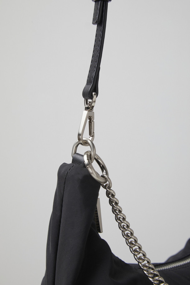 플러피 팝(Fluffy pop) 크로스 20은 여성용 크로스백으로, 미디엄 사이즈의 블랙 나일론 소재 무지 가방입니다. 반원 모양에 체인 장식이 더해져 미니멀, 클래식, 시크한 스타일을 연출합니다. 생활 방수 기능과 탈부착 가능한 스트랩으로 실용성을 높였으며, 자연스러운 주름 라인이 특징입니다. 내부에는 지퍼 포켓 1개와 일반 포켓 1개가 있어 수납이 용이하며, 브라스 소재 하드웨어가 고급스러움을 더합니다. 출근룩, 모임룩, 데이트룩 등 다양한 TPO에 활용 가능합니다.
