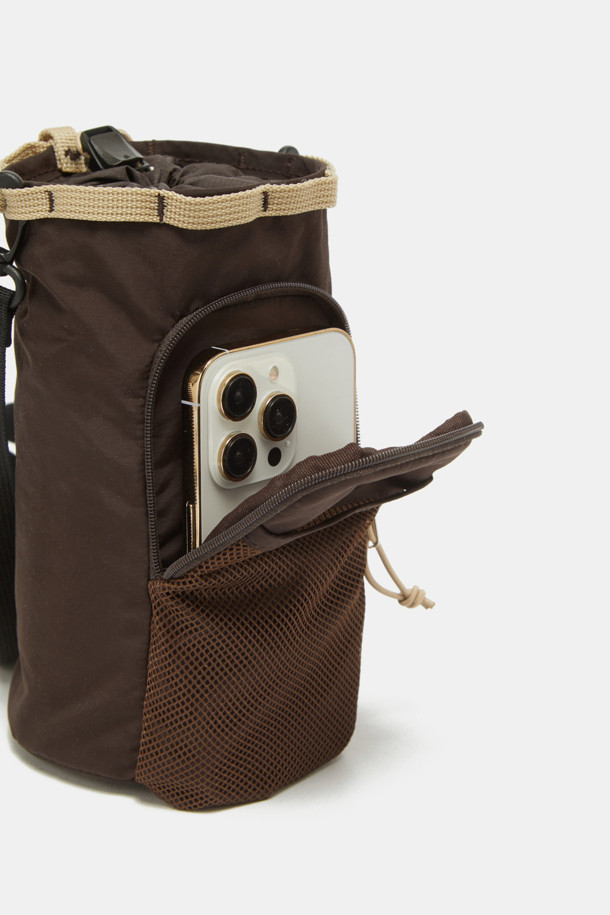 여성용 Bagel Bottle Pouch 9은 퍼플, 레드, 브라운 색상의 미디엄 사이즈 보틀 파우치입니다. 나일론 소재로 제작되었으며, 보온, 보냉 기능과 수납력을 갖춘 원통형 디자인이 특징입니다. 조절 가능한 스트랩, 외부 포켓 1개, 내부 포켓 및 수납공간, 블랙 하드웨어, 내부 쿨링 라이닝이 더해져 여행이나 아웃도어 활동에 유용하며, 메쉬 디자인 장식이 돋보입니다.
