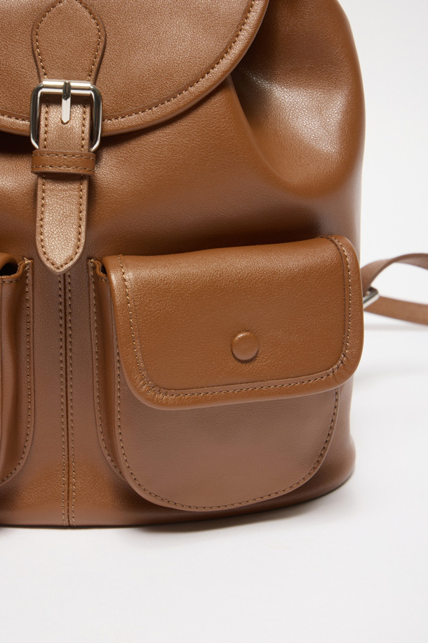 버터니 백팩 24는 부드러운 소가죽 소재의 여성 가방입니다. 브라운 컬러의 무지 디자인으로, 버튼, 지퍼, 드로우스트링 디테일이 돋보이며, 미디엄 사이즈의 사각형 쉐입을 갖추었습니다. 외부 오픈 포켓 2개, 지퍼 포켓 1개, 내부 백패널 오픈 포켓 1개로 실용적인 수납력을 제공하며, 조절 가능한 스트랩으로 편안한 착용감을 선사합니다. 글로시 마감으로 고급스러움을 더하여 데이트룩, 쇼핑룩, 카페룩 등 다양한 TPO에 클래식, 미니멀, 시크 스타일을 연출하기 좋습니다.
