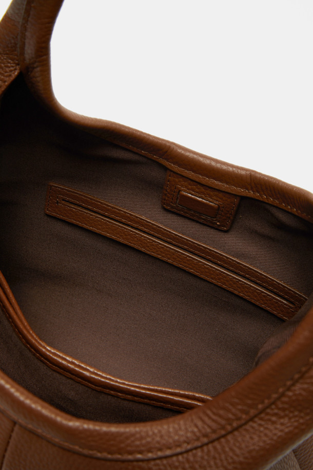 세느 토트 30(Seine Tote 30)은 부드러운 소가죽 소재의 미디엄 사이즈 토트백입니다. 블랙, 브라운, 커스터드 3가지 색상으로 출시되어, 시크하고 미니멀한 스타일을 연출합니다. 3-way 컨버터블 디자인으로, 내장 스트랩과 탈부착 가능한 크로스바디 스트랩을 활용해 다양한 연출이 가능하며, 3개의 수납공간과 중앙 분리 수납공간, 내부 포켓 1개로 실용성을 더했습니다. 출근룩, 모임룩 등 TPO에 맞춰 클래식하게 활용하기 좋으며, 가죽 특유의 자연스러운 질감과 시간이 지날수록 생기는 패티나가 멋을 더합니다.
