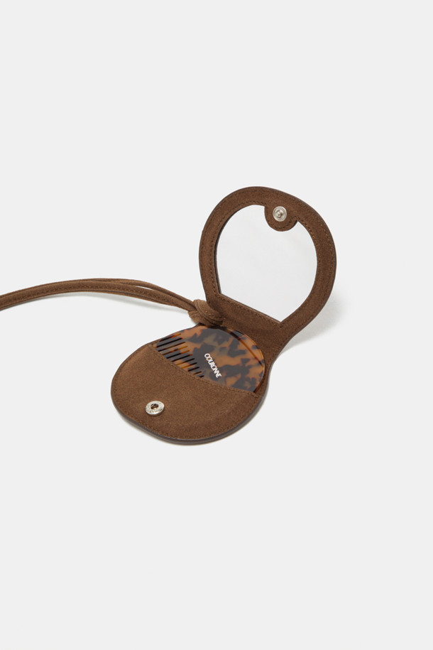 Billo 미러 브러쉬 참은 미니멀, 클래식, 캐주얼 스타일을 즐기는 분들을 위한 가방 참입니다. 부드러운 스웨이드와 합성가죽 소재를 사용하여 은은한 광택과 유려한 곡선 라인이 돋보이며, 브라운과 블랙 두 가지 컬러로 출시되었습니다. 원형 디자인에 거울과 브러쉬가 내장되어 실용성을 더했으며, 긴 끈이 포함되어 있어 데이트룩, 쇼핑룩 등 다양한 TPO에 활용하기 좋습니다. 일반 레더 소재보다 가볍고, 물이나 오염물 침투를 방지하여 여름철에도 쾌적하게 착용할 수 있습니다.
