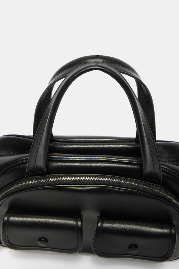 Buttony Tote 33 (버터니 토트 33)은 여성용 가방으로, 미디엄 사이즈의 블랙 컬러 가죽 토트백입니다. 클래식하고 미니멀한 스타일을 추구하며, 시크한 분위기를 연출합니다. 사각형 모양에 버클 디테일로 포인트를 주었으며, 손잡이와 숄더 스트랩이 있어 다양한 연출이 가능합니다. 오피스룩, 비즈니스 캐주얼, 모임룩 등 TPO에 맞춰 활용할 수 있는 실용적인 가방입니다. 버클형 잠금 방식으로 소지품을 안전하게 보관할 수 있습니다.
