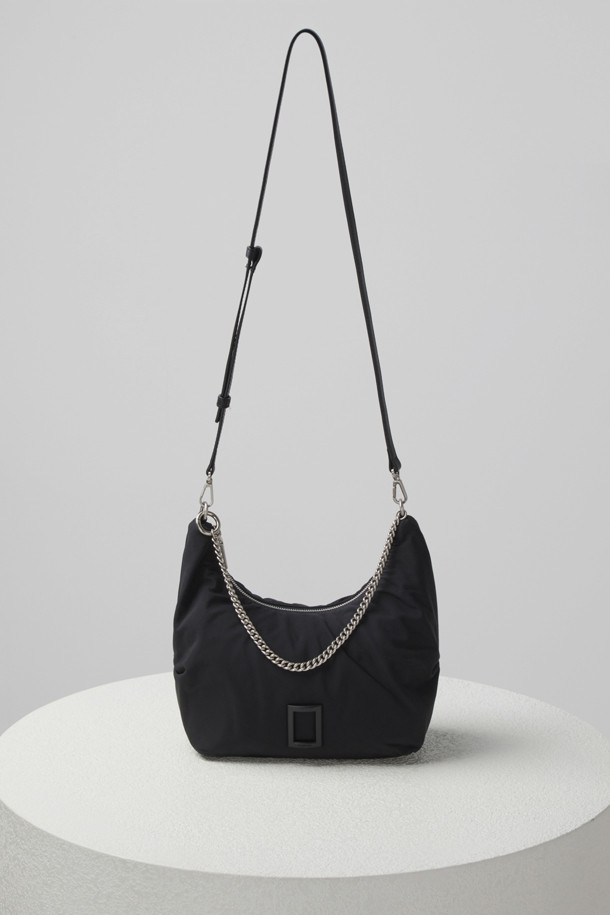 플러피 팝(Fluffy pop) 크로스 20은 여성용 크로스백으로, 미디엄 사이즈의 블랙 나일론 소재 무지 가방입니다. 반원 모양에 체인 장식이 더해져 미니멀, 클래식, 시크한 스타일을 연출합니다. 생활 방수 기능과 탈부착 가능한 스트랩으로 실용성을 높였으며, 자연스러운 주름 라인이 특징입니다. 내부에는 지퍼 포켓 1개와 일반 포켓 1개가 있어 수납이 용이하며, 브라스 소재 하드웨어가 고급스러움을 더합니다. 출근룩, 모임룩, 데이트룩 등 다양한 TPO에 활용 가능합니다.
