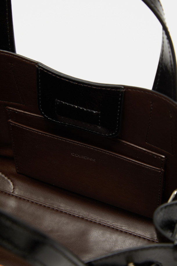 Fermier Day 토트 27은 여성용 미디엄 사이즈 토트백입니다. 블랙 색상의 합성가죽 소재로 제작되었으며, 버클과 체인 디자인 장식으로 시크한 포인트를 더했습니다. 3-way 착용이 가능하며, 탈부착 스트랩, 내부 포켓, 실버 하드웨어, 버클형 잠금 방식으로 실용성을 높였습니다. 무지 패턴의 사각 쉐입으로, 데일리 및 오피스룩에 클래식하고 미니멀한 스타일을 완성합니다.
